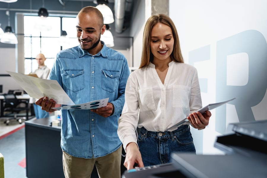 Two coworkers at the printer
